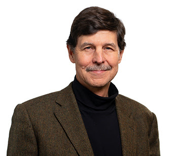 Headshot of David Woolner, Ph.D in a brown jacket and black turtle neck